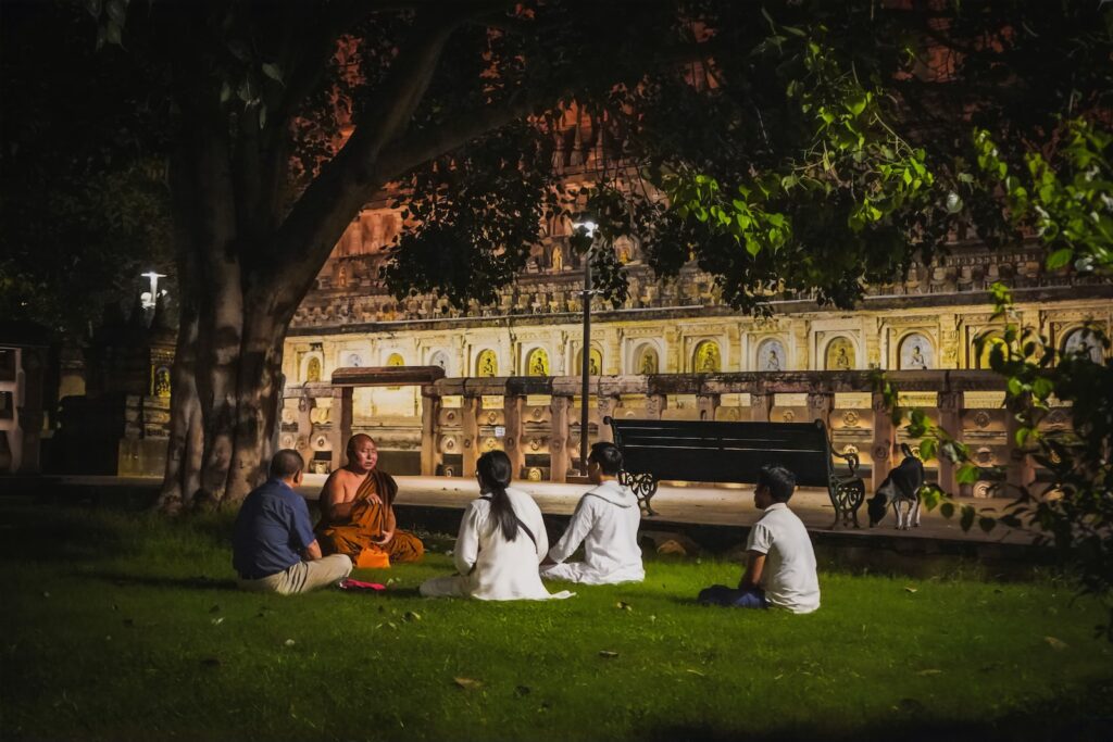 vipassana, meditação, a group of people sitting on the grass in front of a building