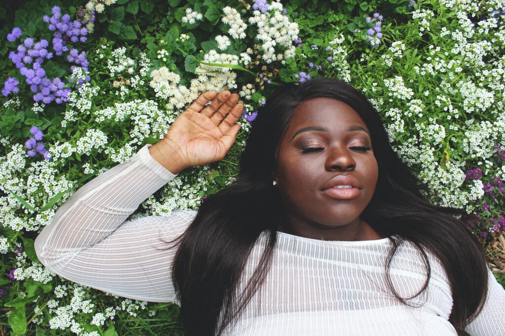 woman wearing white shirt lying on green grass