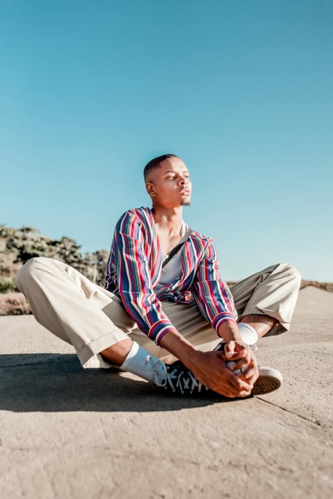 Man Sitting On Concrete Pavement