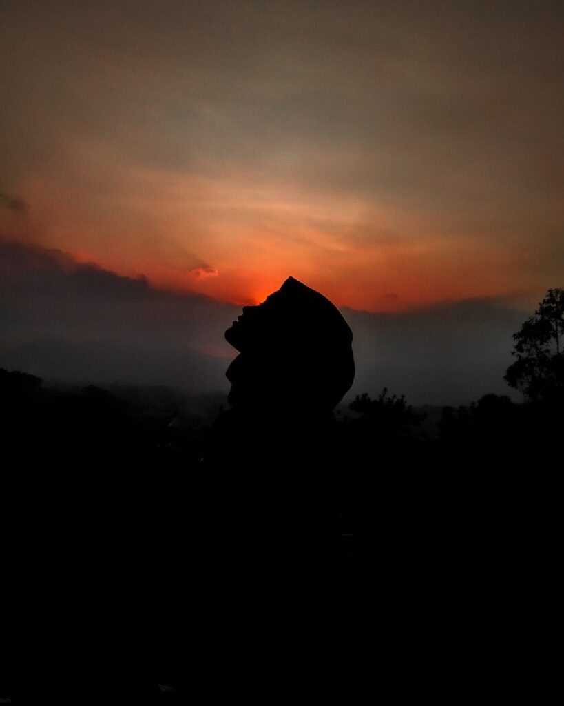 Silhouette of person against sunset sky