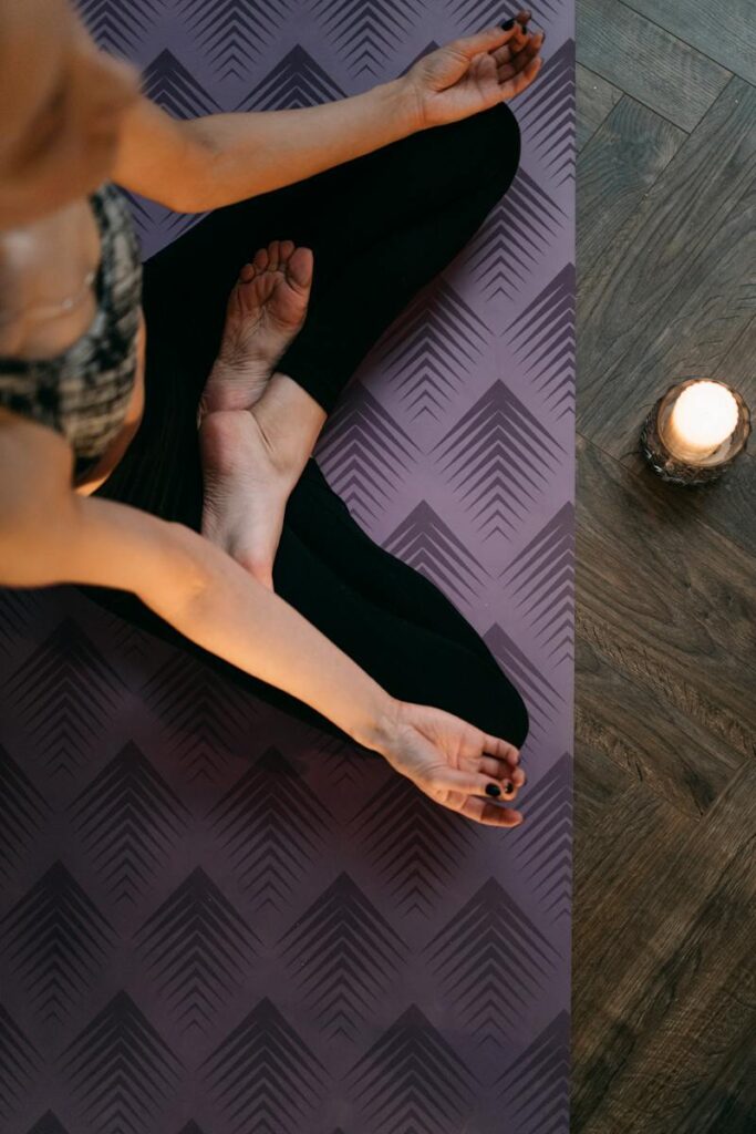 Overhead Shot of a Woman Meditating Near a Candle