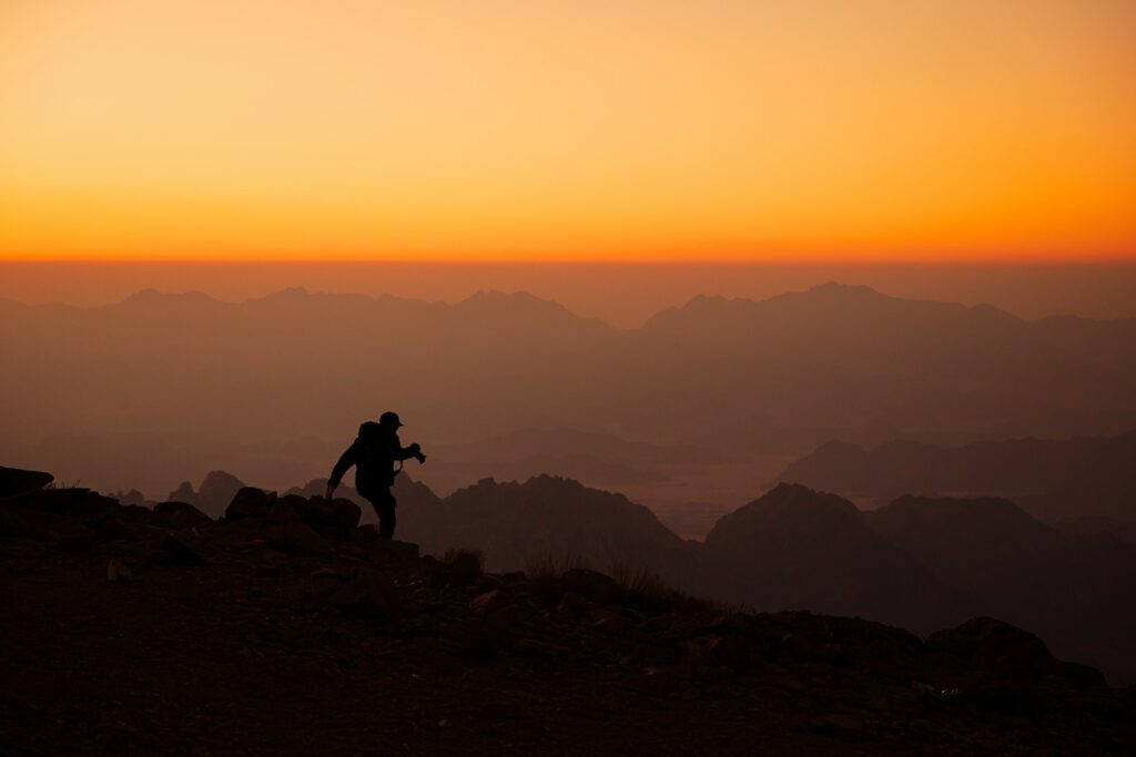 a person standing on top of a mountain at sunset